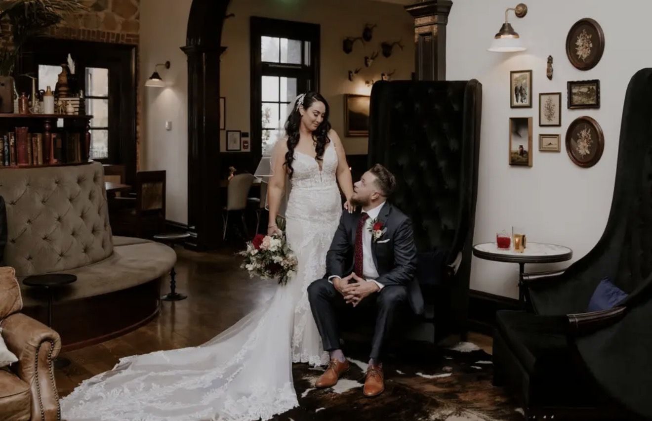 A bride and groom seated in a historic hotel lounge